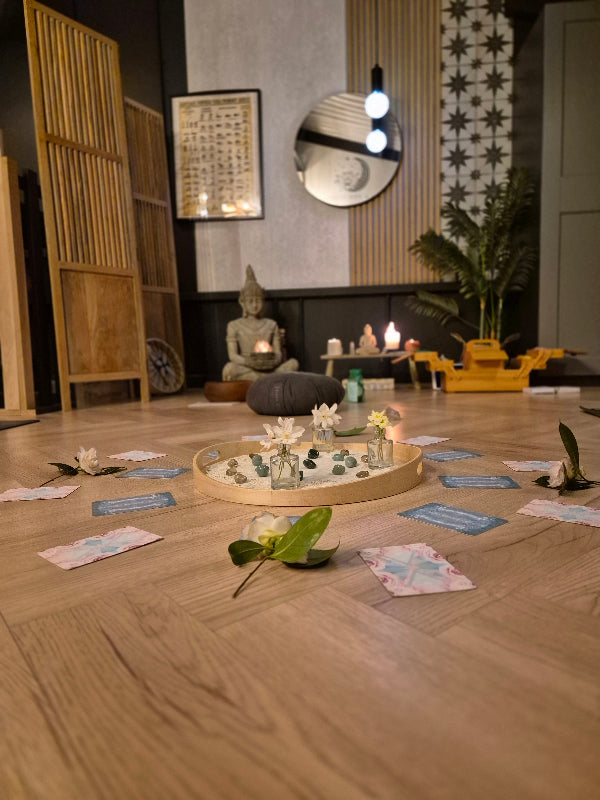 studio floor set up for a crystal circle with crystals, flowers and oracle cards laid out